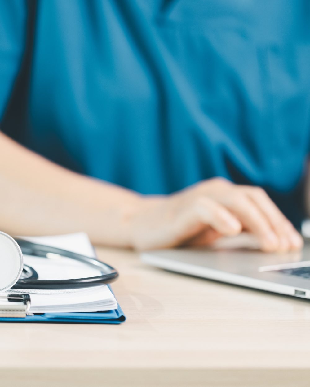Profissional da saúde usando o laptop para acompanhar as finanças da clínica